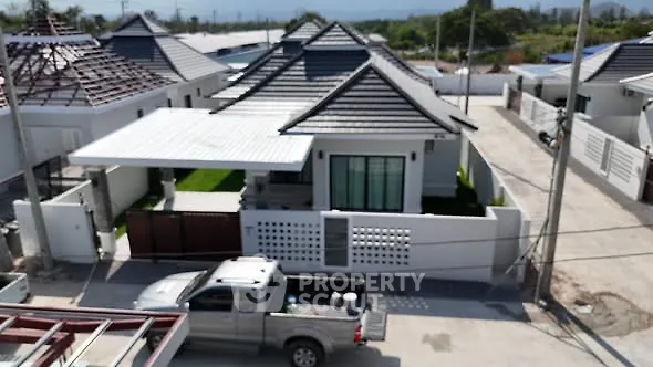 Modern single-story house with carport and landscaped yard in a suburban neighborhood.