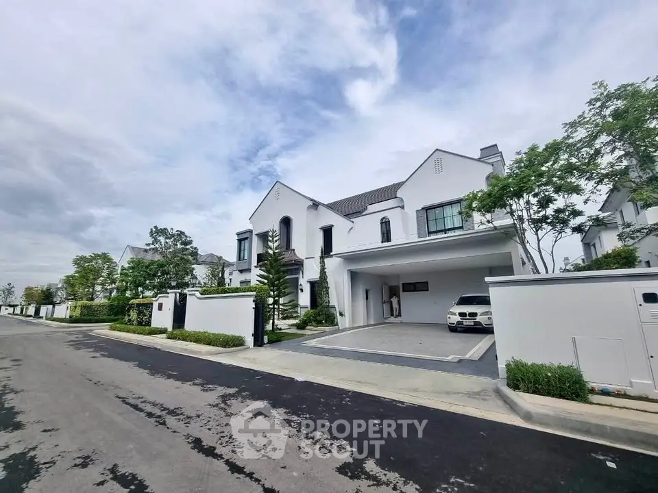 Elegant modern house with spacious driveway and lush greenery in a serene neighborhood.