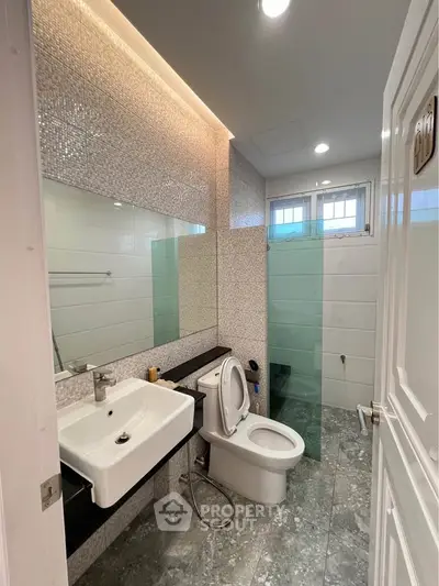 Modern bathroom with sleek design, featuring a glass shower and stylish fixtures.