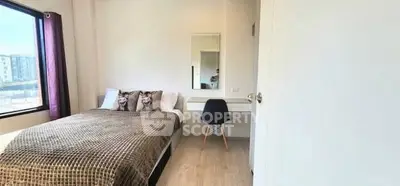 Bright and cozy bedroom with modern decor and large window view.