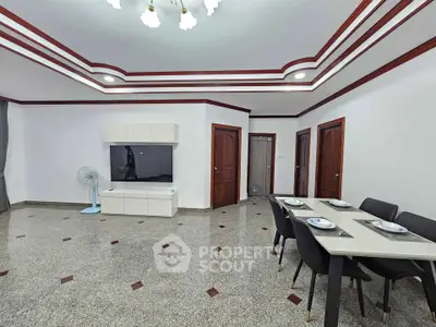 Spacious modern living room with elegant dining area and stylish ceiling design.