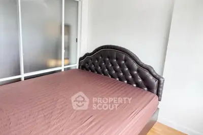 Spacious bedroom with elegant leather headboard and sliding closet doors.