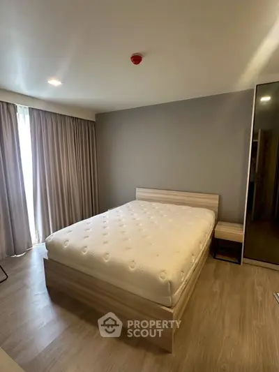 Modern bedroom with cozy bed and stylish decor in a well-lit apartment.