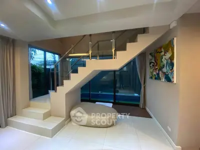 Modern interior with stylish staircase and pool view, perfect for luxury living.