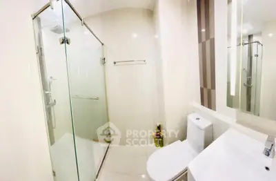 Modern bathroom with glass shower and sleek fixtures in a contemporary home.