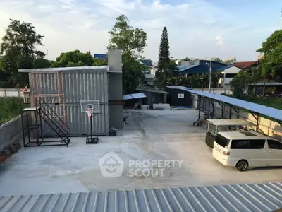 Spacious outdoor parking area with basketball hoop and modern metal structures.