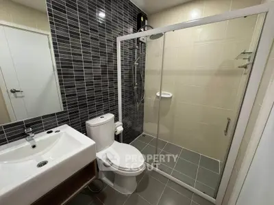 Modern bathroom with sleek design featuring glass shower enclosure and stylish tile work.