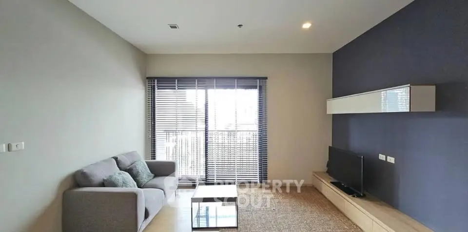 Modern living room with sleek furniture and large window for natural light.