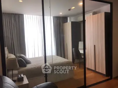 Modern bedroom with stylish decor and ample natural light, featuring a cozy bed and sleek furniture.