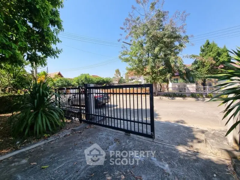 Charming residential entrance with secure gate and lush greenery