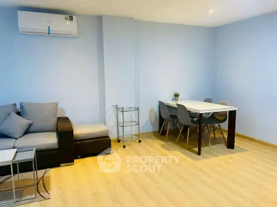 Modern living room with stylish furniture and dining area in a cozy apartment.