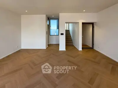 Spacious modern living room with elegant wooden flooring and recessed lighting.