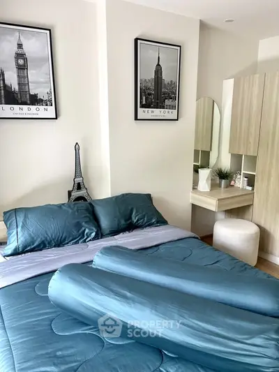 Chic bedroom with modern decor and stylish cityscape artwork, featuring a cozy bed and elegant vanity area.