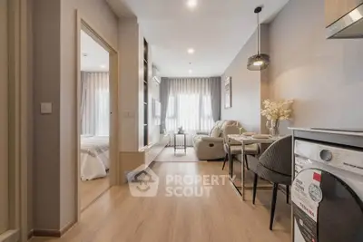 Modern open-plan living room with dining area and washing machine in stylish apartment.