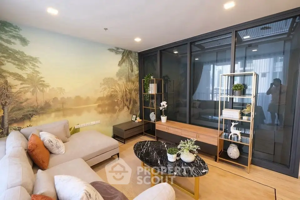 Elegant living room with modern decor and large sofa, featuring a scenic wall mural and stylish furniture.