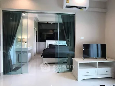 Modern bedroom with glass sliding doors and sleek furnishings