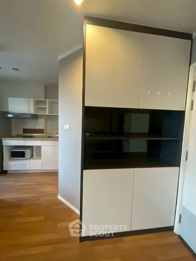 Modern kitchen with sleek cabinetry and hardwood floors in a stylish apartment.