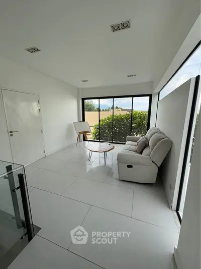 Bright minimalist living room with large windows and modern furniture