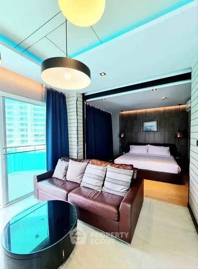 Modern studio apartment with stylish living area and cozy bedroom, featuring a large window with city view.
