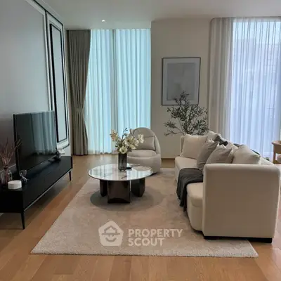 Elegant living room with modern decor, featuring a cozy sofa, stylish coffee table, and large TV.
