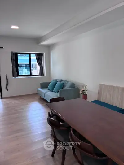Spacious living room with modern furniture and natural light, perfect for relaxation and entertaining.