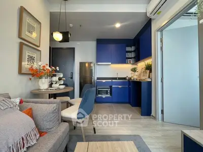 Modern living room with open kitchen, stylish decor, and cozy seating area in a contemporary apartment.