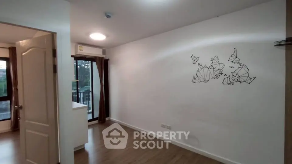 Spacious unfurnished room with wooden flooring and modern wall art, ideal for customization.