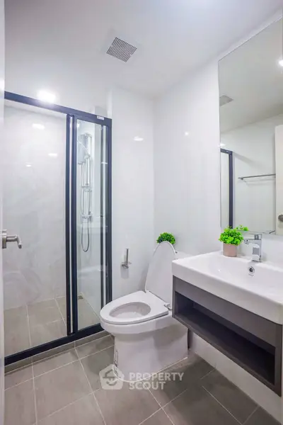 Modern bathroom with glass shower and sleek fixtures in a contemporary home.