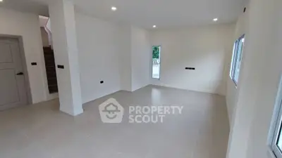Spacious unfurnished living room with large windows and modern lighting