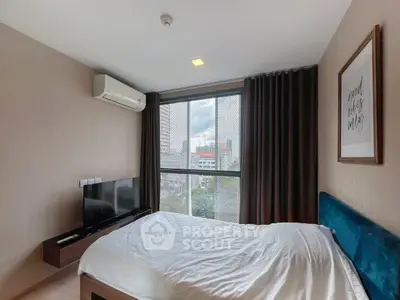 Modern bedroom with large window and city view, featuring a wall-mounted TV and stylish decor.