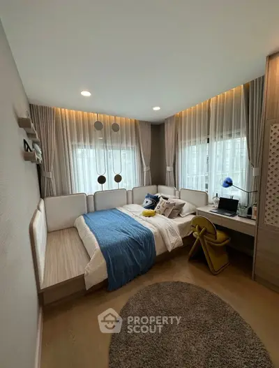 Cozy bedroom with modern decor, featuring a stylish bed, desk, and elegant lighting.