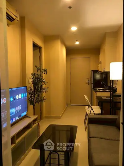 Cozy apartment living room with modern decor and compact kitchen area.