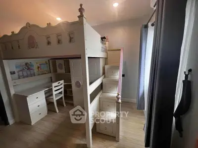 Charming children's bedroom with loft bed and study area, perfect for family living.