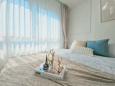 Cozy bedroom with elegant decor and large window offering natural light