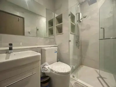 Modern bathroom with glass shower and sleek fixtures in a contemporary apartment.