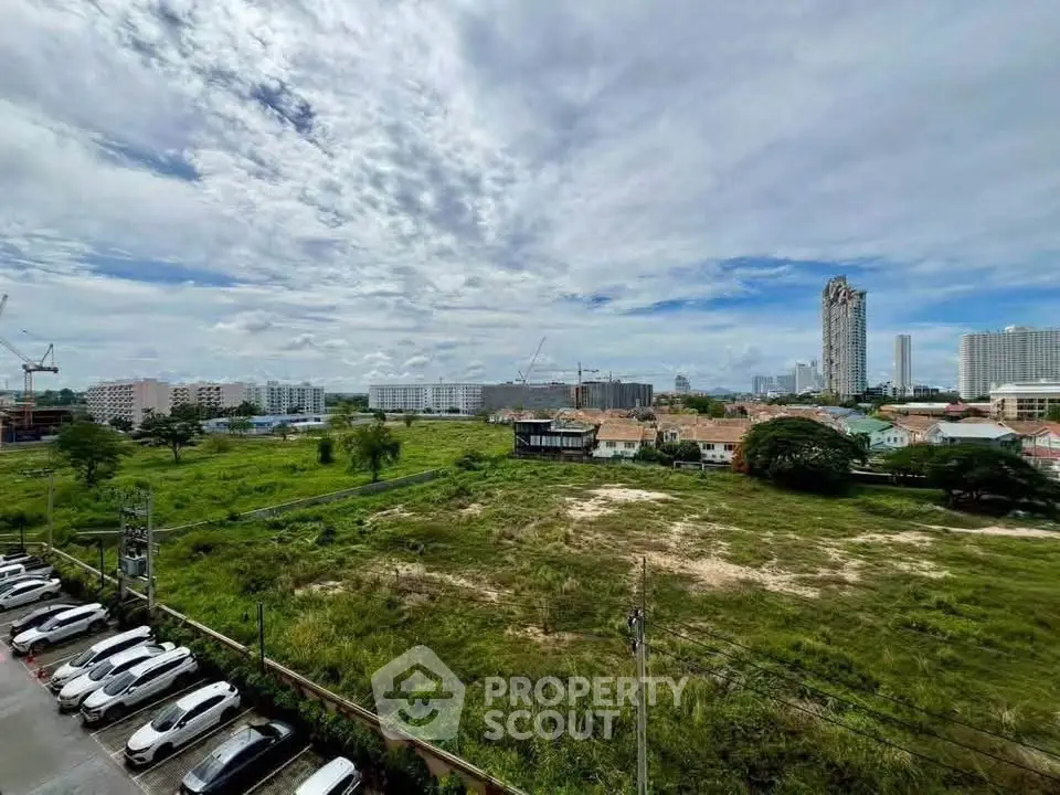 Expansive cityscape view with lush greenery and urban skyline, ideal for real estate development.