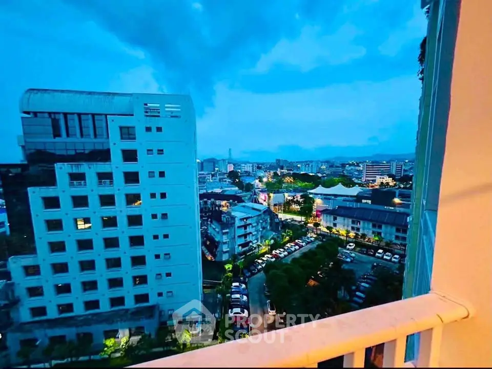 Stunning cityscape view from a high-rise balcony at dusk, showcasing urban skyline and vibrant lights.