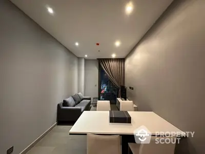 Modern minimalist living room with sleek white dining table, cozy gray sofa, and warm ambient lighting, perfect for urban living.