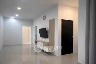 Modern minimalist living room with sleek TV setup and glossy flooring