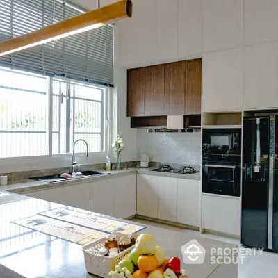 Modern kitchen with sleek design, featuring gas stove and ample natural light.