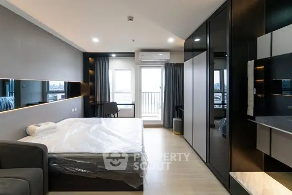 Modern bedroom with city view, sleek design, and ample storage space.