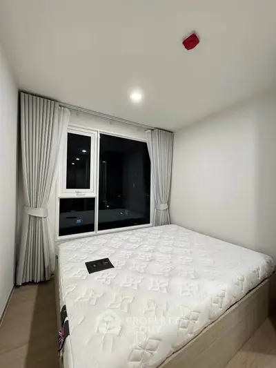 Cozy bedroom with large window and modern decor in a stylish apartment.