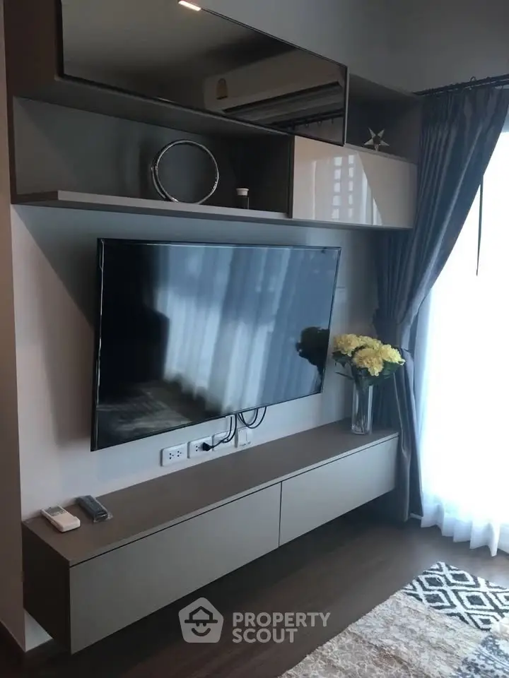 Modern living room with sleek TV unit and elegant decor in a stylish apartment.