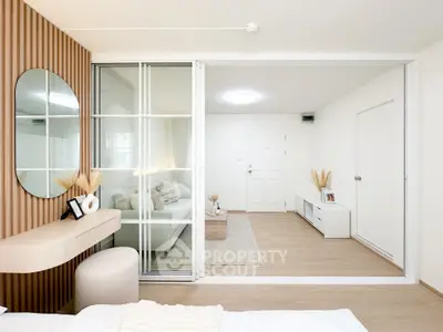 Modern living room with stylish decor and sliding glass doors, featuring a cozy seating area and elegant wooden accents.