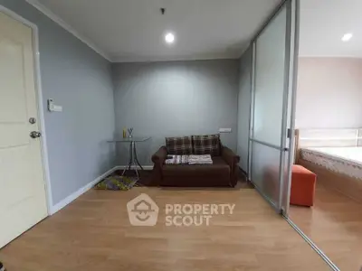 Cozy living area with modern decor and sliding glass doors leading to a bedroom.