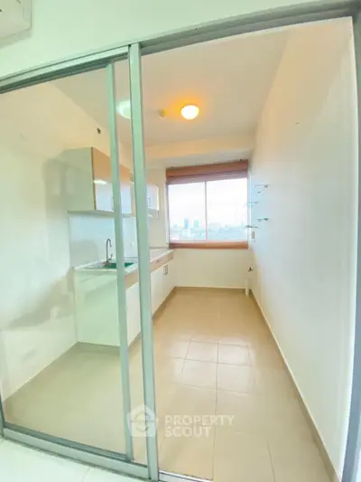 Bright kitchen with closed layout and city view, featuring modern cabinetry and ample natural light.