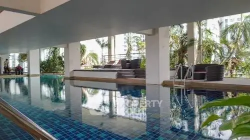 Luxurious indoor pool area with modern design and lush greenery views.
