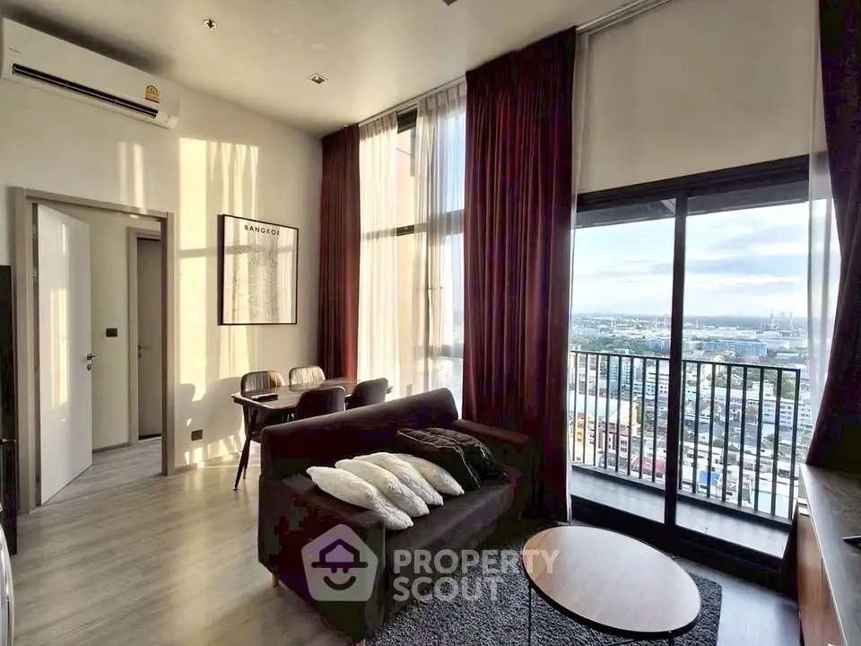 Modern living room with large windows and city view, featuring stylish furniture and elegant decor.