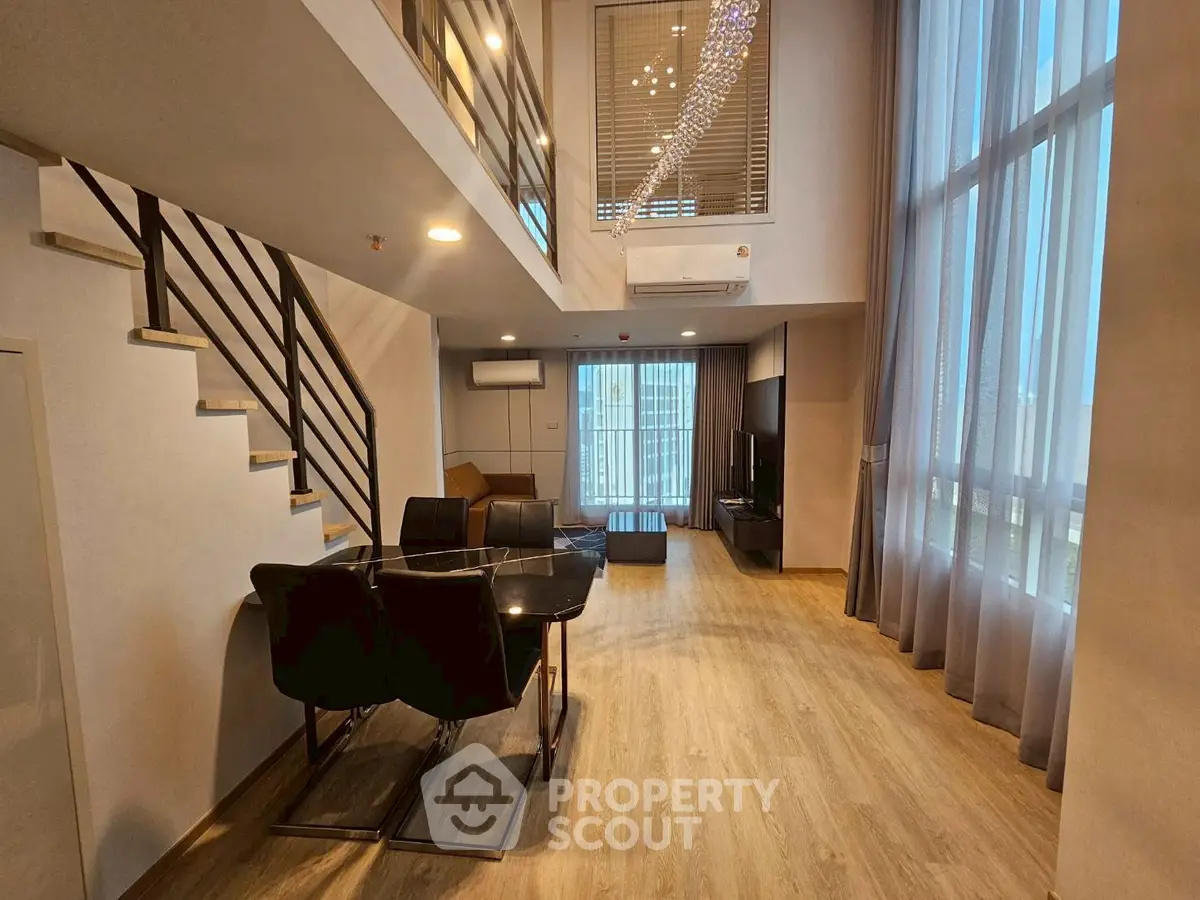 Spacious modern living room with high ceilings and elegant decor in a luxurious duplex apartment.