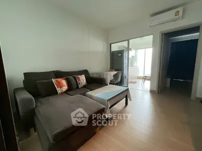 Cozy living room with modern sofa and open kitchen layout in a stylish apartment.